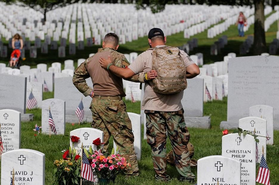 Military Men Consoling each other by graveside